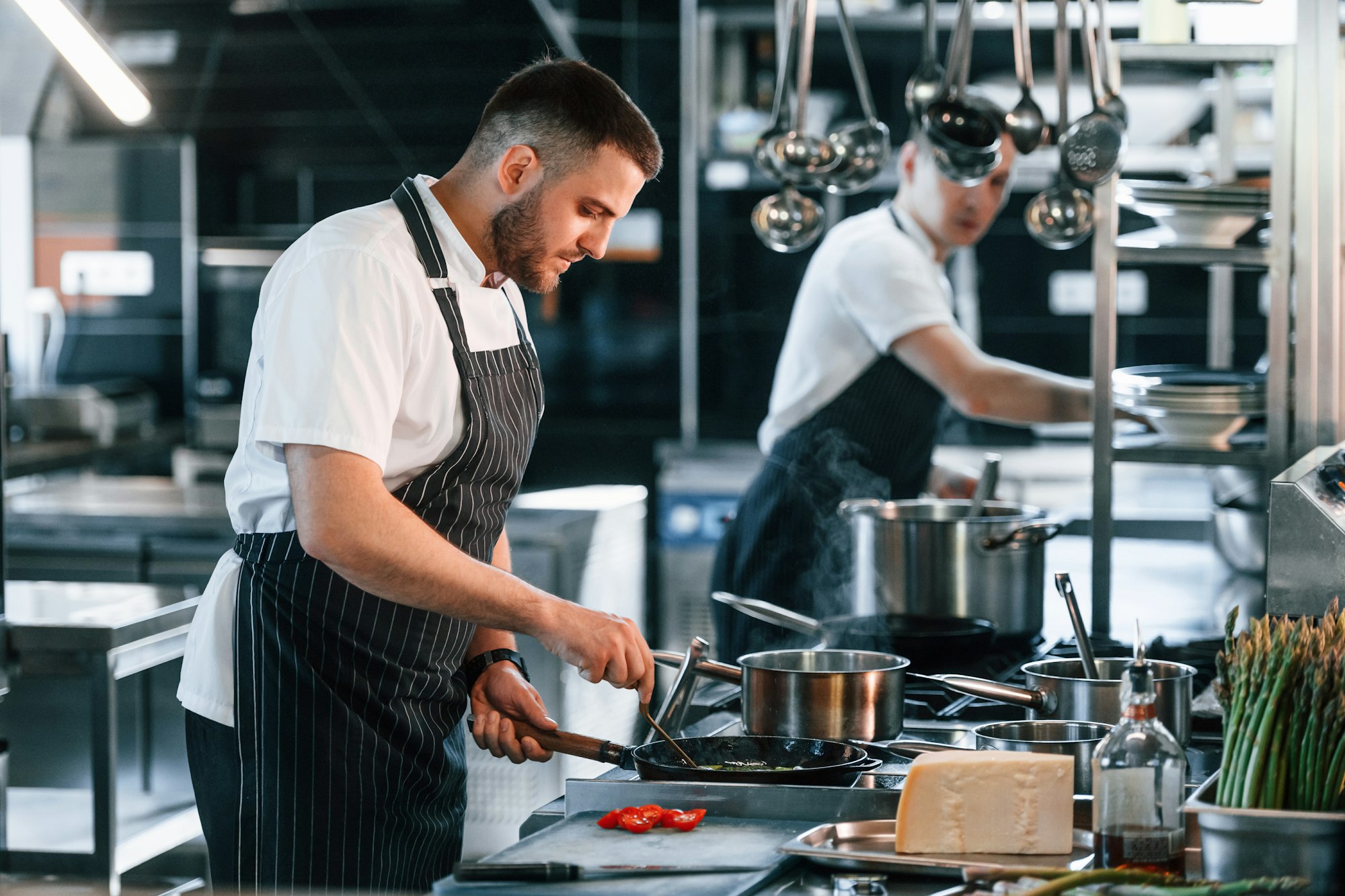 In uniform. Kitchen workers is together preparing the food